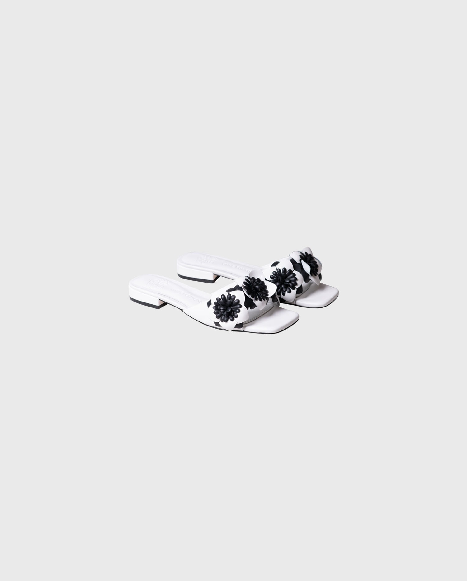 Discover the COLORADO white leather slip ons with black flowers from ANNE FONTAINE