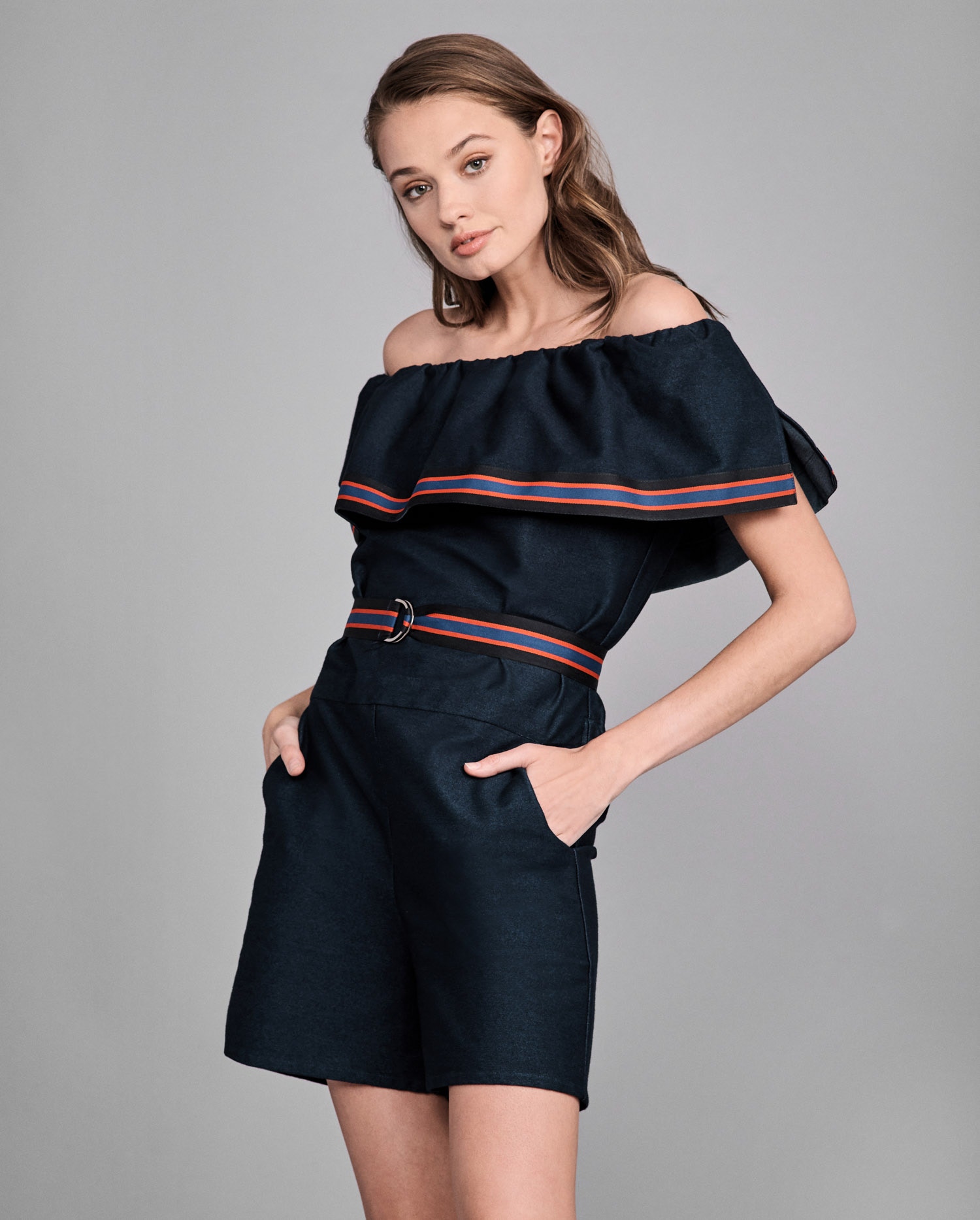 Discover the VIRGIE Dark wash denim romper with flounce ruffle