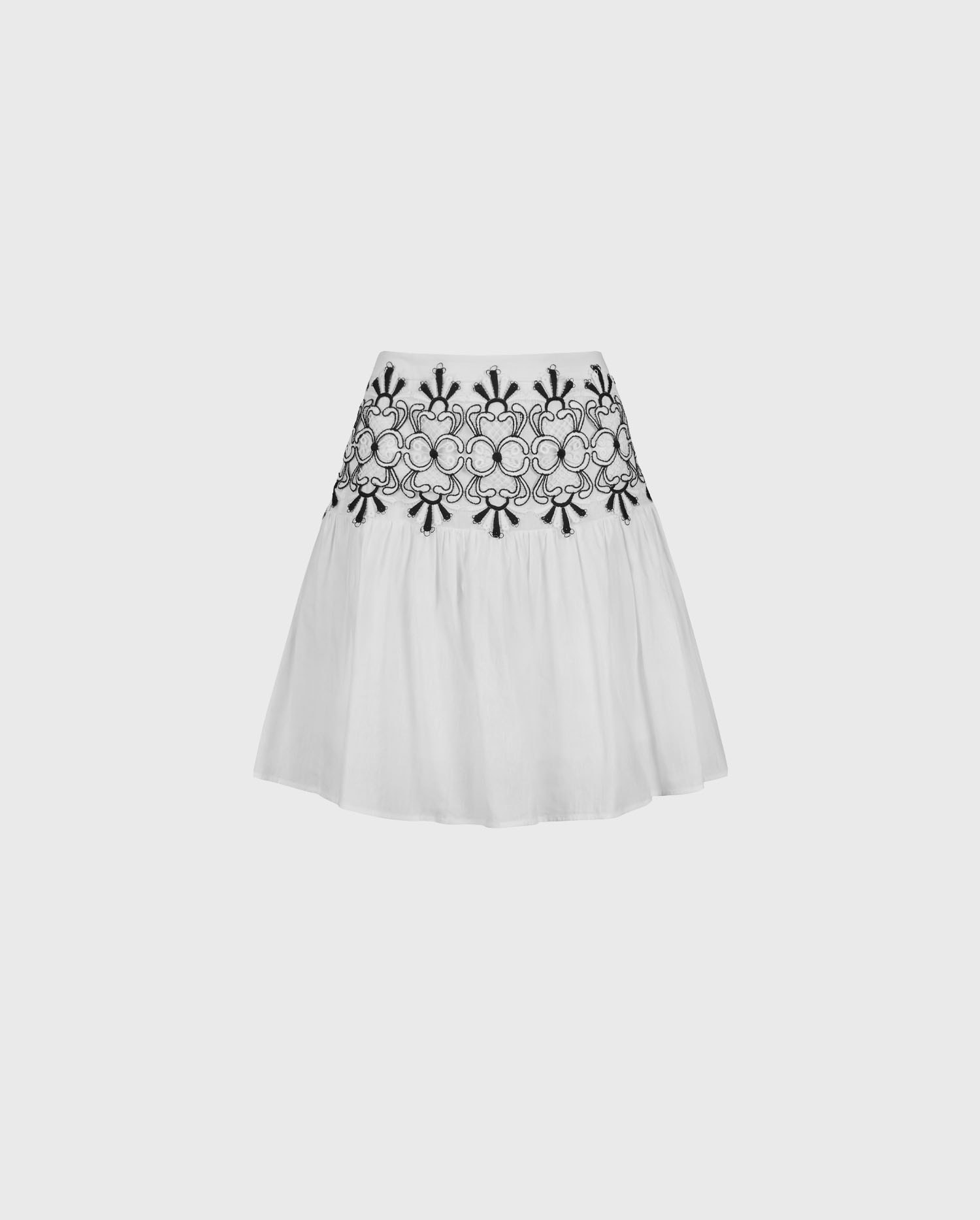 Explore the ANGLET Skirt white pleated linen mini skirt with intricate black lacework embroidery throughout the top