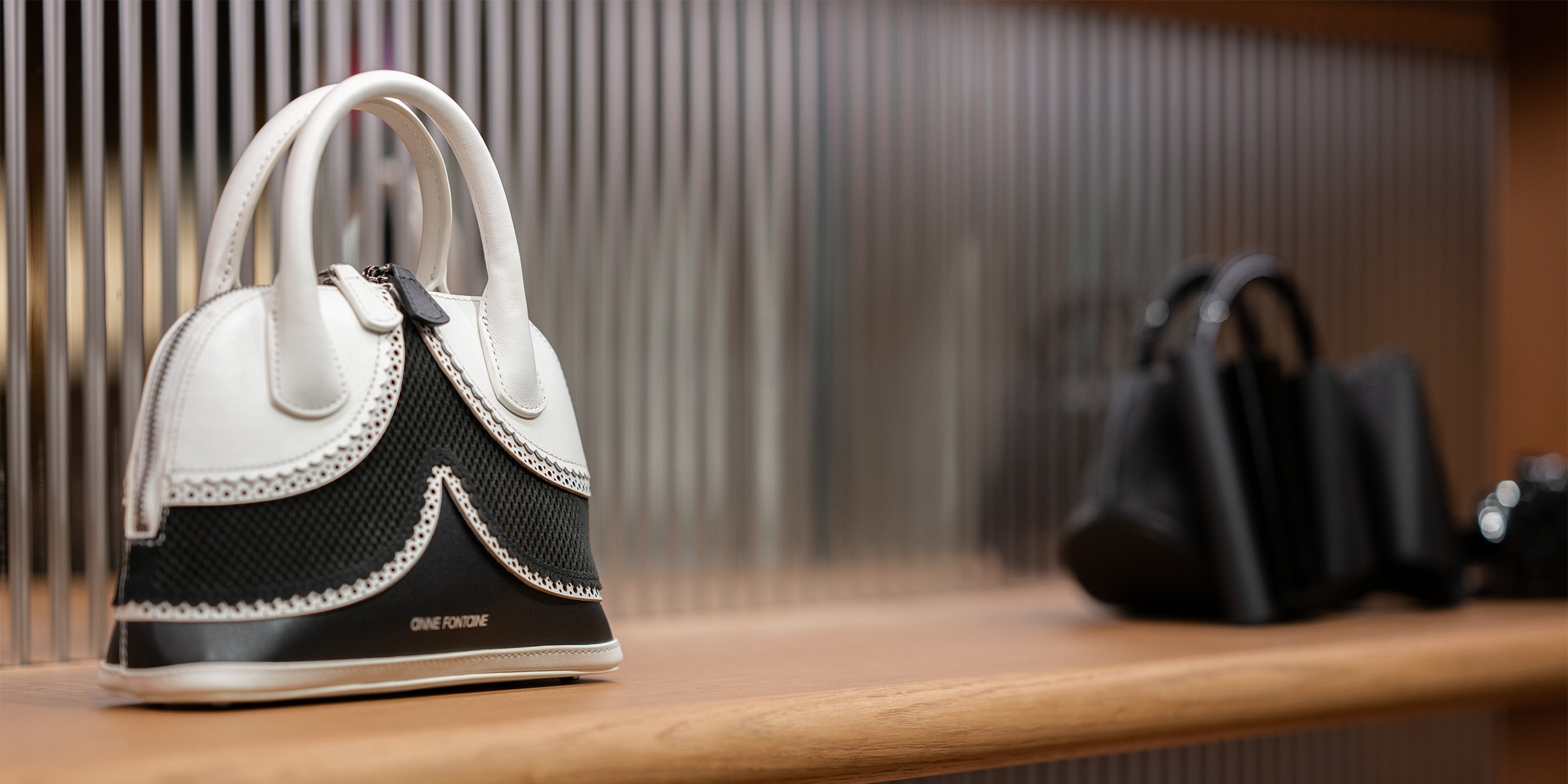 Discover the JANAE Black and White Leather Handbag With Eyelet Trims from ANNE FONTAINE