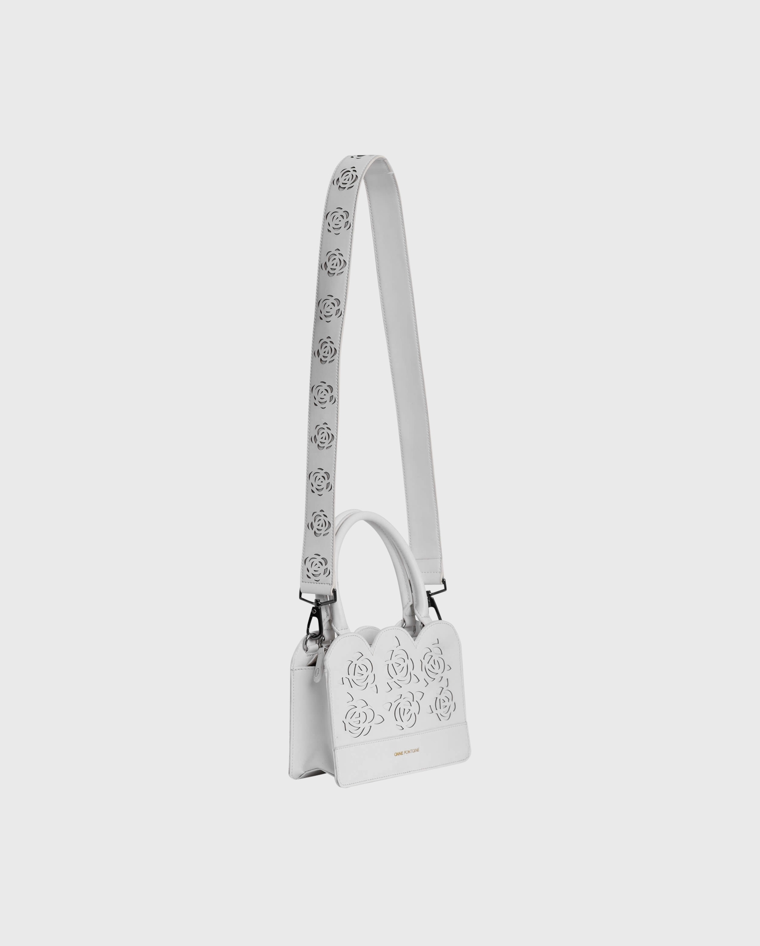 The IURY white leather floral handbag is the perfect companion piece.
